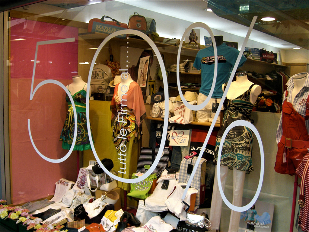 Vetrofania per saldi con scritte in PVC adesivo prespaziato applicate alla vetrina del negozio